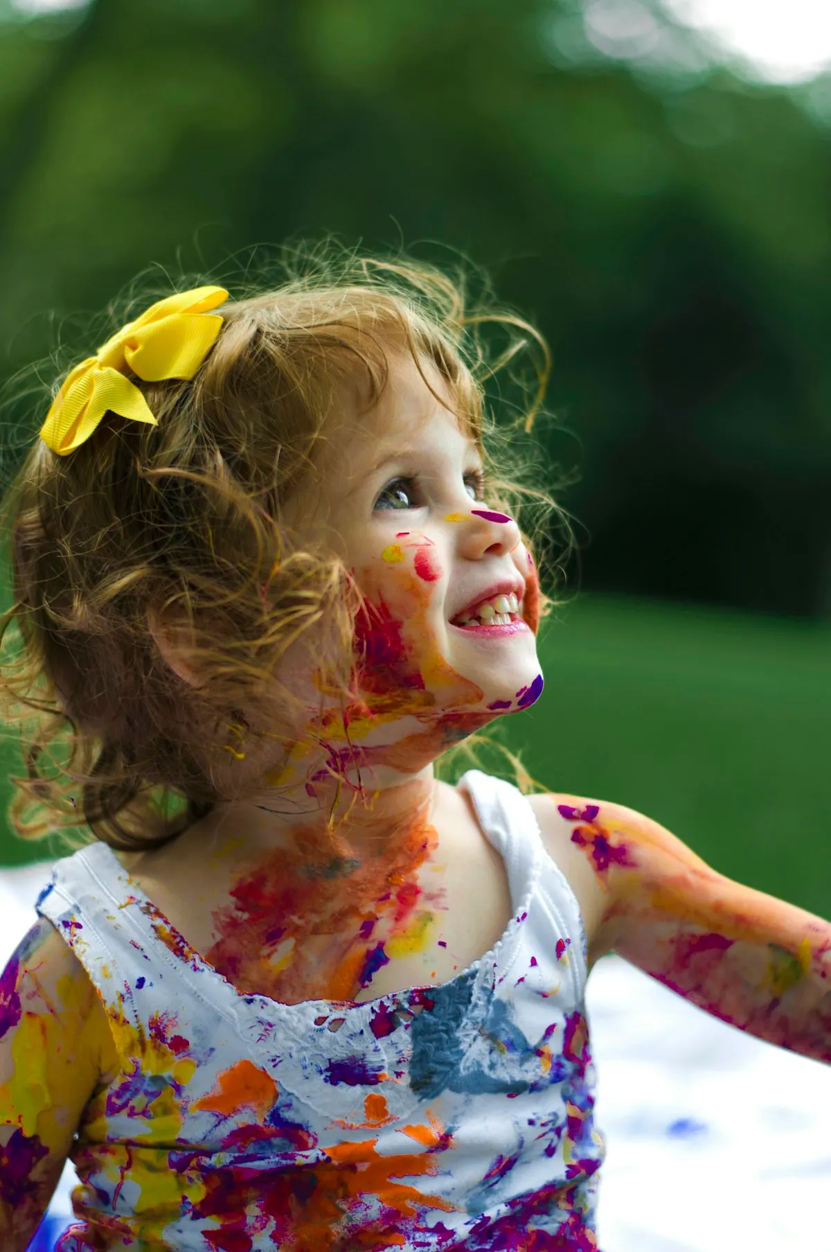 Une enfant souriante couverte de peinture